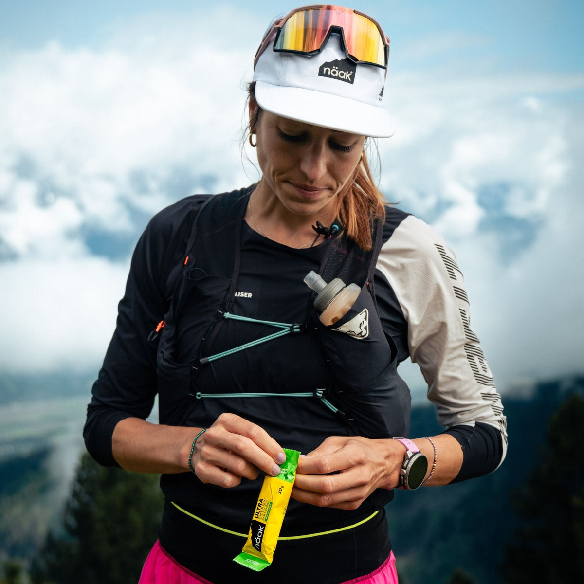 Woman athlete is holdng a naak almond-chocolate ultra energy bar
